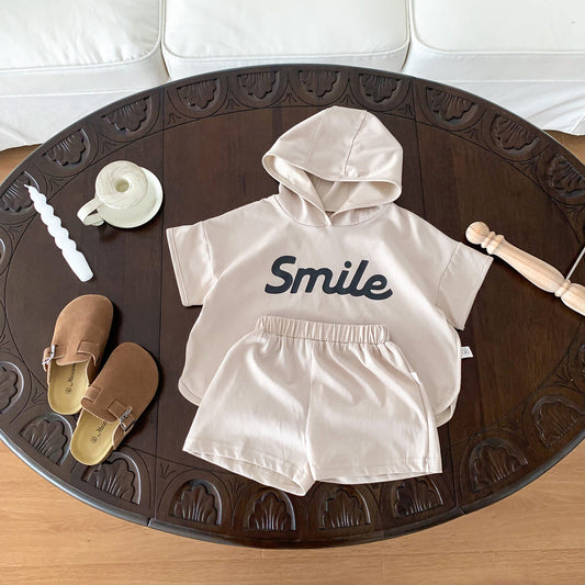 A smiling parent holding a baby while checking a modern baby monitor in a softly lit nursery, radiating warmth, comfort, and peace of mind.