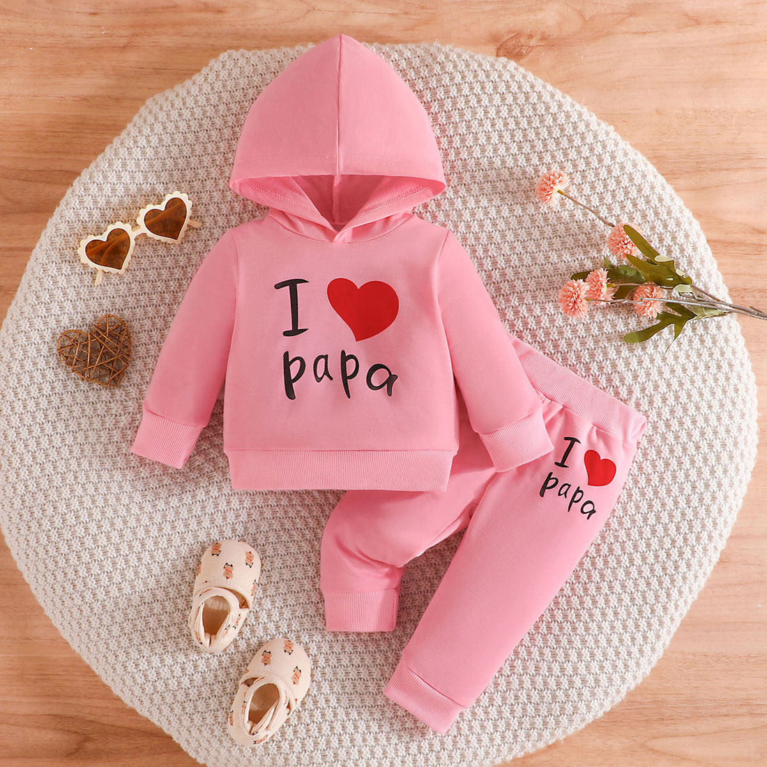 A smiling baby wearing a cozy onesie holds a teething toy, surrounded by soft blankets and gentle sunlight, highlighting teething comfort and care.