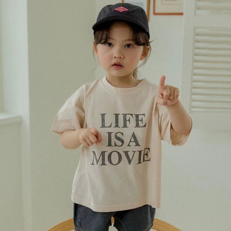 A smiling child cuddles a Baby Alive doll in a cozy playroom, surrounded by colorful outfits, blankets, and joyful pretend play accessories.